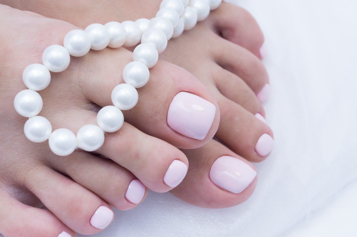Ongles longs en dégradé rose avec paillettes blanches à la pointe.